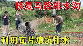 Fixing the rain-damaged road with tiles from our yard it drains water and levels the ground the