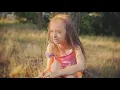 A father watches his daughter and puts a camera in her hair