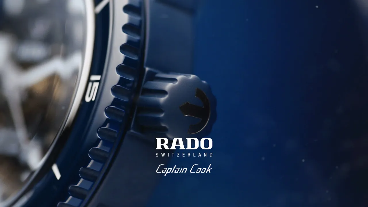 The video opens with a close-up of a Rado Captain Cook skeleton watch, showcasing its intricate mechanical movement. The…