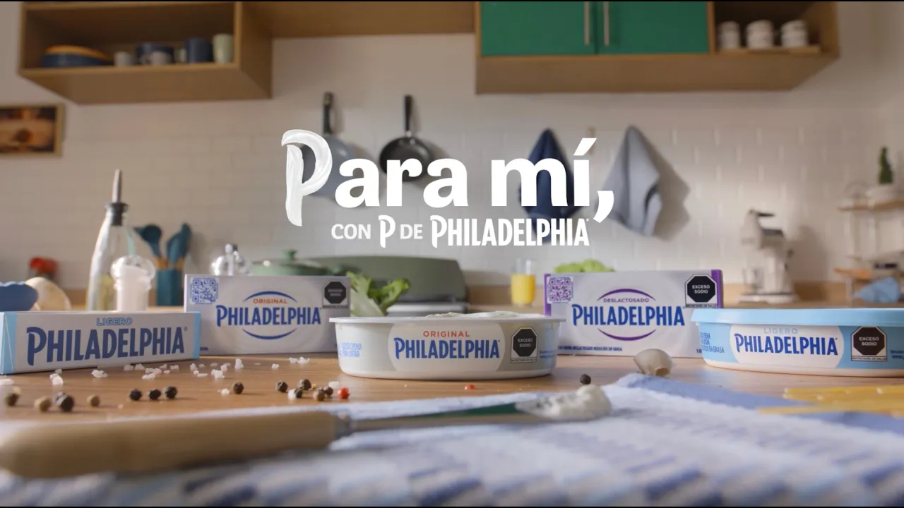 The ad opens with a close-up of a hand using a knife to spread cream cheese from a Philadelphia container onto a slice of…