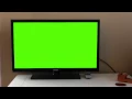 Hand met afstandsbediening zet greenscreen-tv aan (rechtenvrij gebruik)