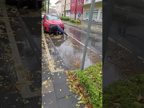 S#079-1 Unclogging a storm drain on a parking space during rain in Germany, #shorts