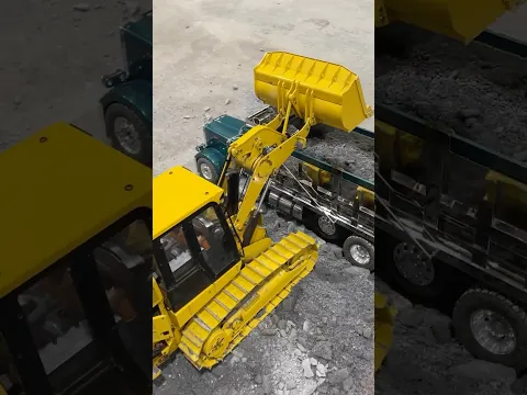 Hydraulic RC track loader dumping dirt in a tri axle