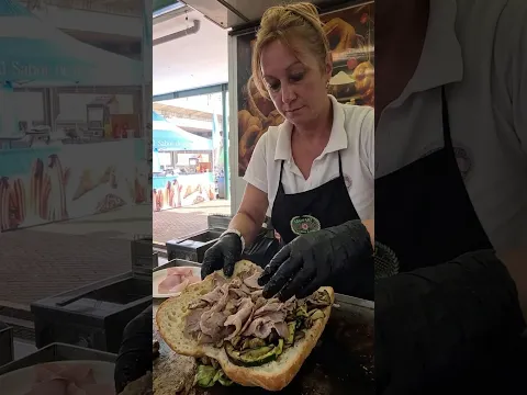 Grilling Pork Roast for Big Italian Sandwiches. Street Food Fair in Turin, Italy